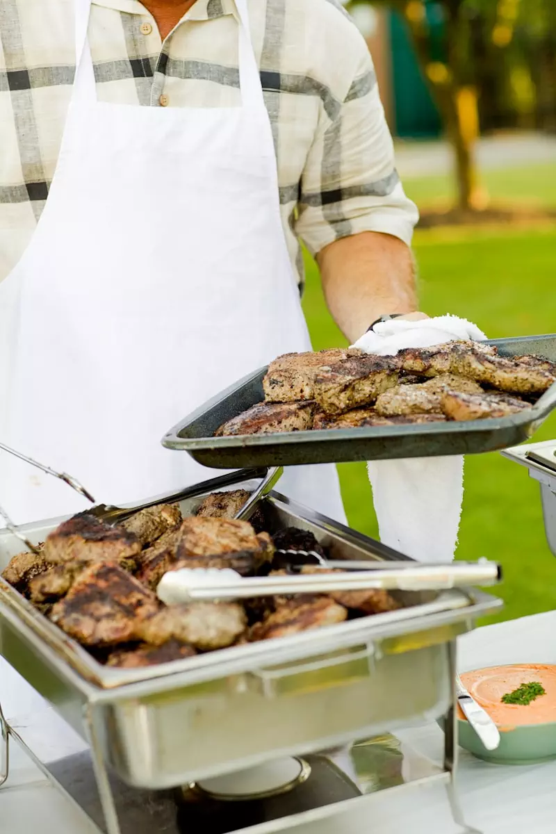 Photo by Amanda Kerr person holding tray filled with grilled meat